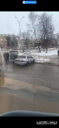 На ямы в лужах обращает внимание водителей пассажир трамвая